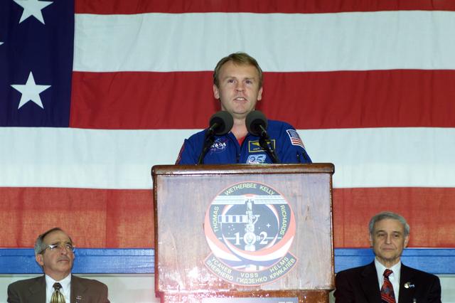 JSC2001-E-08329 (22 March 2001) --- Astronaut Andrew S.W. Thomas, STS-102 mission specialist, speaks to a crowd of greeters during a crew return ceremony in Hangar 990 at Ellington Field. In the background are Joseph Rothenberg (left), NASA Associate Administrator for Space Flight, and Roy S. Estess, Acting Director of the Johnson Space Center (JSC).