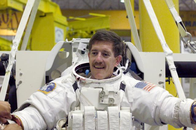 JSC2001-E-10909 (13 April 2001) --- Astronaut James F. Reilly, mission specialist, gets help with final touches on the training version of his Extravehicular Mobility Unit (EMU) space suit prior to being submerged in the waters of the Neutral Buoyancy Laboratory (NBL) at the Johnson Space Center (JSC). The STS-104 mission to the International Space Station (ISS) represents the Space Shuttle Atlantis&#0146; first flight using a new engine and is targeted for a liftoff no earlier than June 14, 2001.