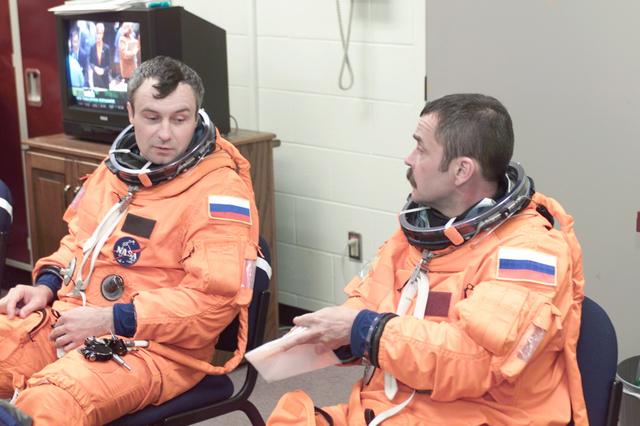 JSC2001-E-12449 (24 April 2001) --- Suited in training versions of the full-pressure launch and entry suit, cosmonauts Vladimir N. Dezhurov (left) and Mikhail Tyurin, await a training session in one of the trainer/mockups (out of frame) in the Systems Integration Facility at Johnson Space Center (JSC). Dezhurov and Tyurin, who represent Rosaviakosmos, are both crew members for Expedition Three.