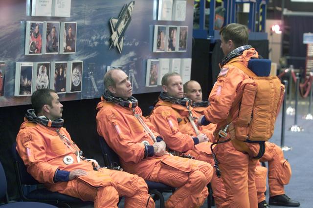JSC2001-E-12454 (24 April 2001) --- Equipped with training versions of the full-pressure launch and entry suit, several members of the STS-105 crew await the start of a training session in one of the trainer/mockups (out of frame) in the Systems Integration Facility at Johnson Space Center (JSC).