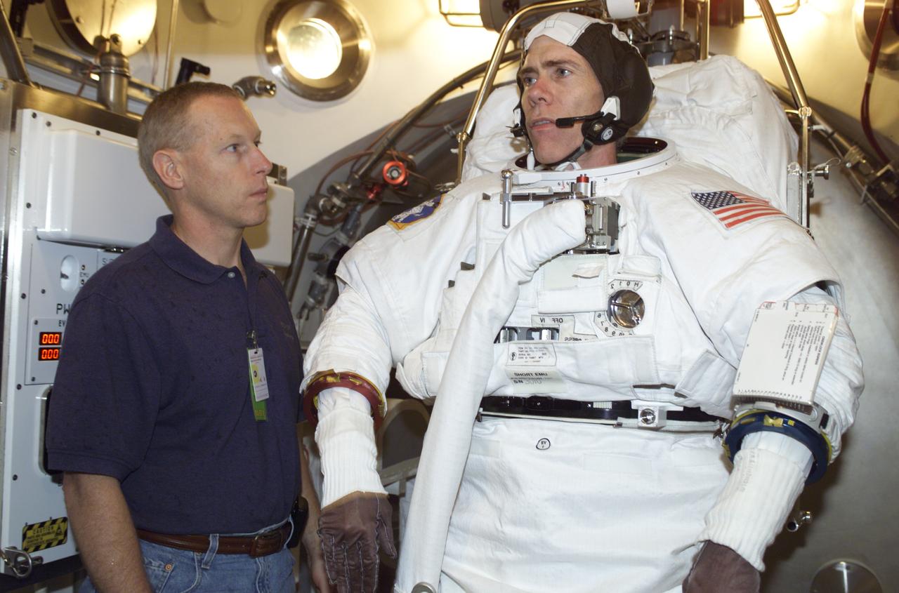 JSC2001-E-18352 (5 June 2001) --- Astronauts Patrick G. Forrester (left) assists Daniel T. Barry, both STS-105 mission specialists, in an Extravehicular Mobility Unit (EMU) fit check in a Space Station Airlock Test Article (SSATA) in the Crew Systems Laboratory at the Johnson Space Center (JSC).