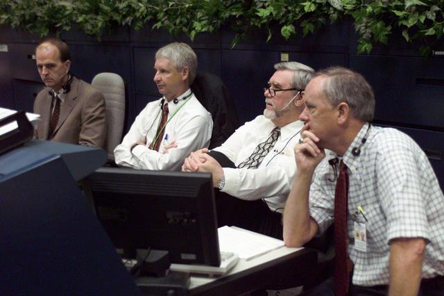 JSC2001-E-21323 (12 July 2001) --- From left to right, Robert Gest with United Space Alliance; Steven A. Hawley, deputy director of Flight Crew Operations;  Alan L. (Lee) Briscoe, chief  engineer for the Mission Operations Directorate (MOD);  and J. Milton (Milt) Heflin, chief of the Flight Director's Office, watch the monitor at the MOD console during the pre-launch activity for the  STS-104 mission in the shuttle flight control room (WFCR) of Houston's Mission Control Center (MCC).