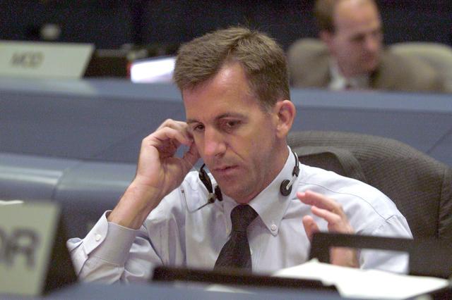 JSC2001-E-21328 (12 July 2001) --- Flight director LeRoy Cain directs his attention to data related to the Space Shuttle Atlantis and its impending launch from the Kennedy Space Center (KSC) several hundred miles away from this Houston setting at the Johnson Space Center's Mission Control Center (MCC).  As soon as the vehicle cleared the tower in Florida, the Houston-based team of flight controllers took over the ground control of the flight.