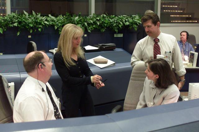 JSC2001-E-21560 (16 July 2001) --- STS-104 flight directors Wayne Hale (seated left), Catherine Koerner (seated right) and Phil Engelauf (standing left) speak with Linda Ham, Special Assistant to the Manager of the Space Shuttle Program Office, at the flight director's console in the shuttle flight control room (WFCR) in Houston's Mission Control Center (MCC).