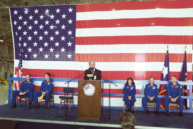 JSC2001-E-22791 (25 July 2001) --- JSC Acting Director Roy S. Estess introduces the STS-104 crew members to a crowd gathered in Ellington Field&#0146;s Hangar 990 during crew return ceremonies. Seated (from left) are Michael L. Gernhardt, James F. Reilly, Janet L. Kavandi, all mission specialists, along with Steven W. Lindsey and Charles O. Hobaugh, mission commander and pilot, respectively.