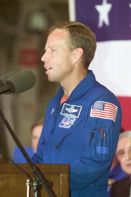JSC2001-E-22793 (25 July 2001) --- Astronaut Steven W. Lindsey, STS-104 mission commander, addresses a crowd at Ellington Field’s Hangar 990 for a crew return ceremony. At lower right is JSC Acting Director Roy S. Estess.