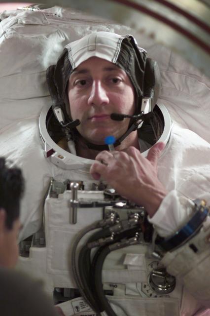 JSC2001-E-44739 (December 2001) --- Astronaut Michael J. Massimino, STS-109 mission specialist, dons a training version of the Extravehicular Mobility Unit (EMU) space suit prior to a mission training session in the Environmental Test Article (ETA) Chamber in the Crew Systems Laboratory at Johnson Space Center (JSC).
