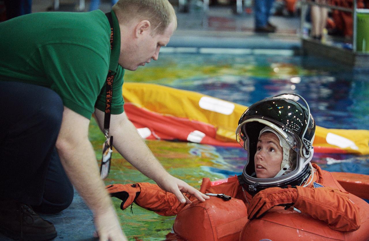 JSC2002-00572 (19 February 2002) --- Astronaut Sandra H. Magnus, STS-112 mission specialist, attired in a training version of the shuttle launch and entry suit, floats in water during an emergency egress training session in the Neutral Buoyancy Laboratory (NBL) near the Johnson Space Center (JSC). Magnus is assisted by United Space Alliance (USA) crew trainer Bob Behrendsen.