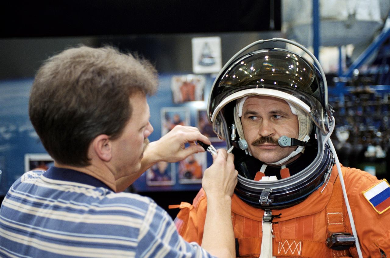 JSC2002-00710 (25 March 2002) --- Cosmonaut Nikolai M. Budarin, Expedition Six flight engineer, assisted by United Space Alliance (USA) suit technician Brad Milling, dons a training version of the shuttle launch and entry suit prior to a mission training session in the Space Vehicle Mockup Facility at the Johnson Space Center (JSC). Budarin represents Rosaviakosmos.