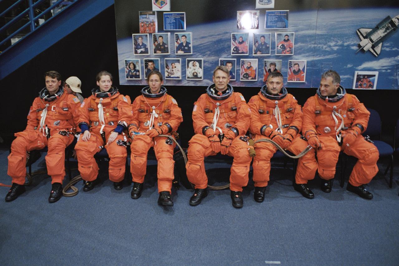 JSC2002-00800 (12 April 2002) --- Attired in training versions of the shuttle launch and entry suit, the STS-112 crew wait for the start of a photo and training session in the Space Vehicle Mockup Facility at the Johnson Space Center (JSC). Seated from the left are astronauts Jeffrey S. Ashby, mission commander; Pamela A. Melroy, pilot; Sandra H. Magnus, Piers J. Sellers, cosmonaut Fyodor N. Yurchikhin and astronaut David A. Wolf, all mission specialists. Yurchikhin represents Rosaviakosmos.