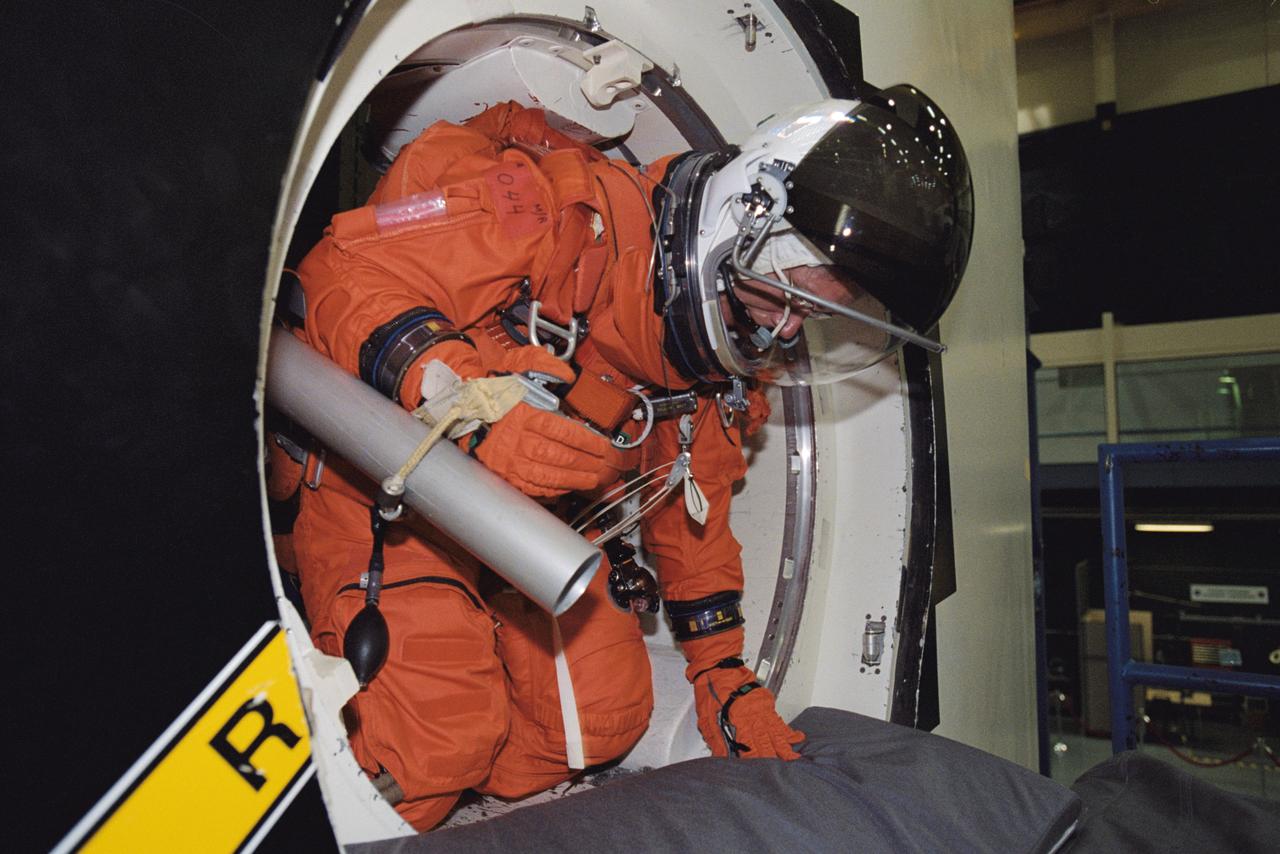JSC2002-00803 (12 April 2002) --- Astronaut Sandra H. Magnus, STS-112 mission specialist, attired in a training version of the shuttle launch and entry suit, rehearses emergency egress procedures in the Space Vehicle Mockup Facility at the Johnson Space Center (JSC). STS-112 will be the 15th shuttle mission to visit the International Space Station (ISS).