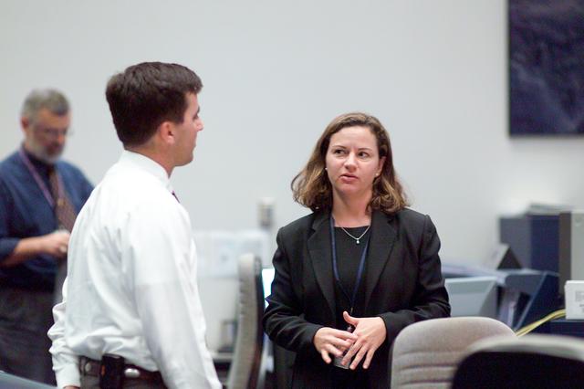 JSC2004-E-45159 (13 October 2004) --- Flight Director Paul Hill and Jennifer L. Hagin, lead Shuttle Data Processing Systems (DPS) officer, discuss the progress of the STS-114 fully-integrated simulations in the shuttle flight control room (WFCR) in Johnson Space Center&#0146;s (JSC) Mission Control Center (MCC). The seven member crew was in a JSC-based simulator during the sims. The dress rehearsal of Discovery's rendezvous and docking with the International Space Station (ISS) was the first flight-specific training for the Space Shuttle's return to flight.