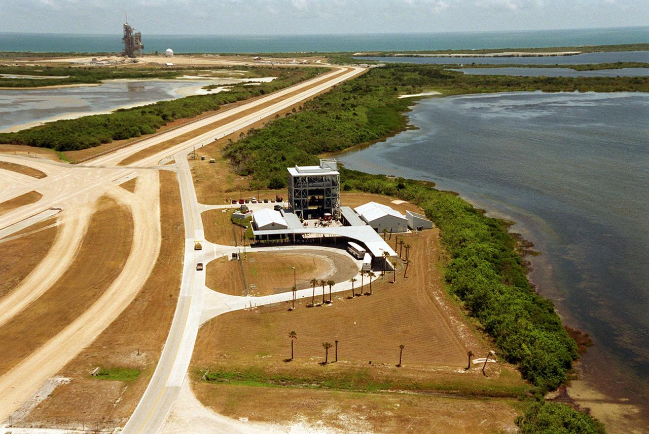 This aerial view is of a tour stop on the KSC bus tour, the Launch Complex 39 Observation Gantry. This stop allows visitors to view and photograph Pads A and B in Launch Complex 39 from an elevated vantage point. The roadway leading to the tour stop runs next to the crawlerway (left) which is used to transport Space Shuttles from the Vehicle Assembly Building to the pads. Pad A can be seen in the background. 