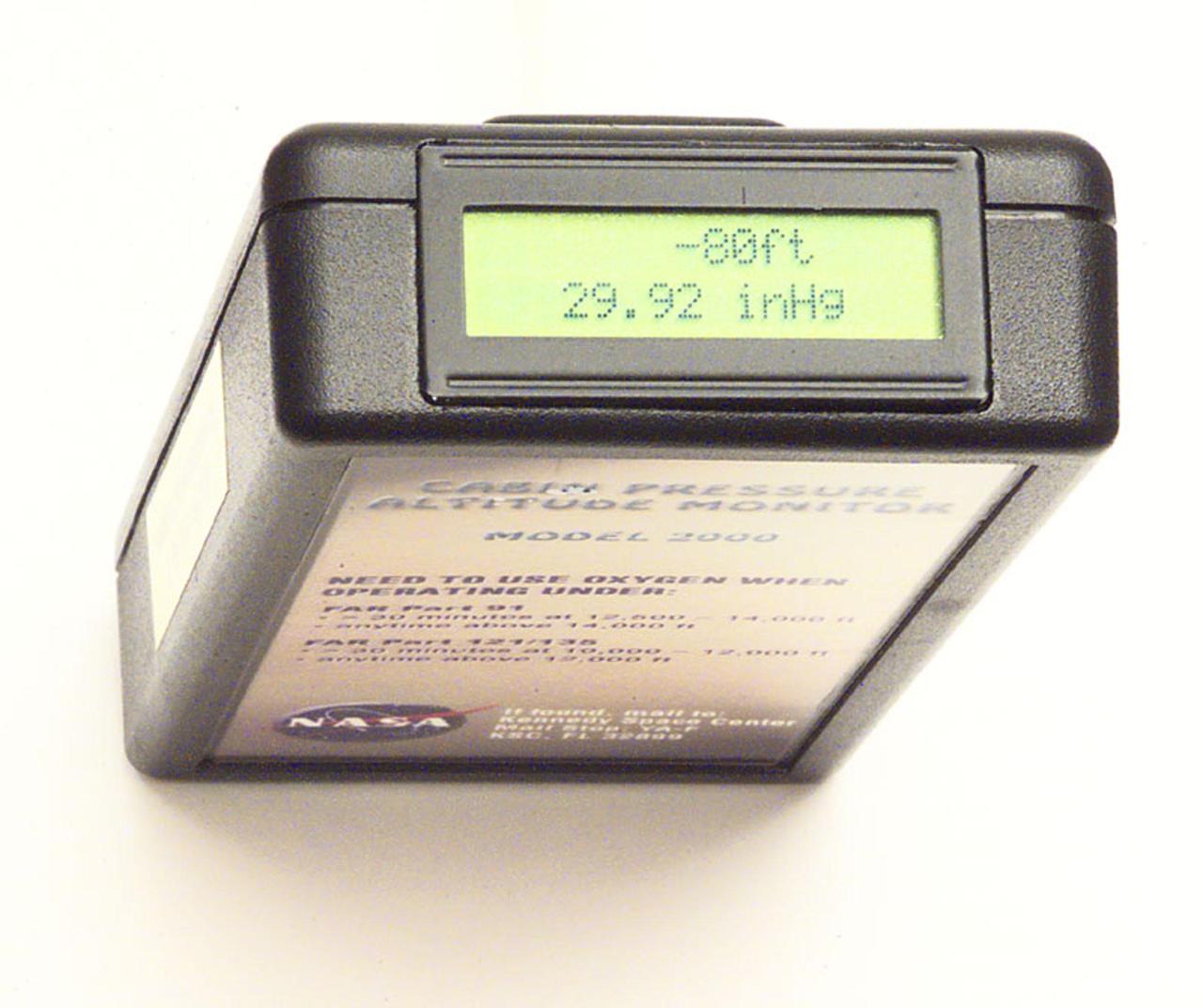This close-up shows the pager-sized Personal Cabin Pressure Altitude Monitor developed by Jan Zysko, chief of the KSC Spaceport Engineering and Technology directorate's data and electronic systems branch. The monitor alerts wearers of a potentially dangerous or deteriorating cabin pressure altitude condition, which can lead to life-threatening hypoxia. Zysko originally designed the monitor to offer Space Shuttle and Space Station crew members added independent notification about any depressurization. However, it has drawn the interest of such organizations as the Federal Aviation Administration for use in commercial airliners and private aircraft as well