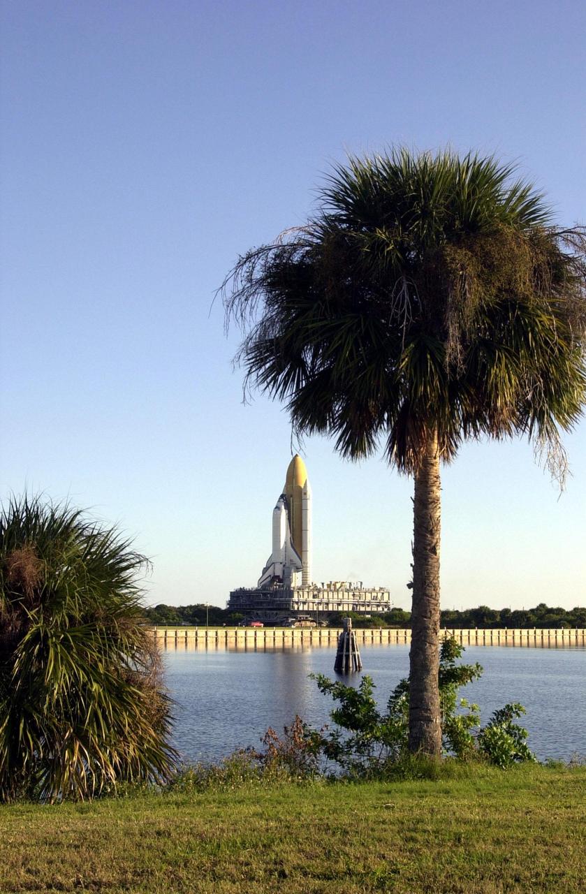 KENNEDY SPACE CENTER, Fla. -- Space Shuttle Endeavour appears to be framed by palms in this view across the turn basin at KSC. Endeavour is inching its way to Launch Pad 39B (on the horizon) via the crawlerway that leads from the Vehicle Assembly Building. The Shuttle is on the Mobile Launcher Platform (MLP) which is atop the crawler-transporter, moving on four double-tracked crawlers. The maximum speed of the loaded transporter is 1 mph. Endeavour is scheduled to be launched Nov. 30 at 10:01 p.m. EST on mission STS-97, the sixth construction flight to the International Space Station. Its payload includes the P6 Integrated Truss Structure and a photovoltaic (PV) module, with giant solar arrays that will provide power to the Station. The mission includes two spacewalks to complete the solar array connections