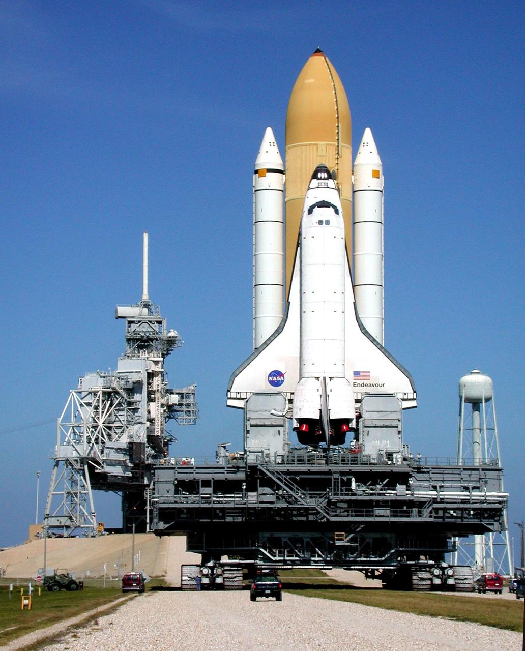KENNEDY SPACE CENTER, Fla. -- Perched atop the Mobile Launcher Platform, Space Shuttle Endeavour passes through the gate to Launch Pad 39B. To the right of the pad is a 290-foot tall water tower. To the left is the Fixed Service Structure and Rotating Service Structure. Endeavour is scheduled to be launched Nov. 30 at 10:01 p.m. EST on mission STS-97, the sixth construction flight to the International Space Station. Its payload includes the P6 Integrated Truss Structure and a photovoltaic (PV) module, with giant solar arrays that will provide power to the Station. The mission includes two spacewalks to complete the solar array connections