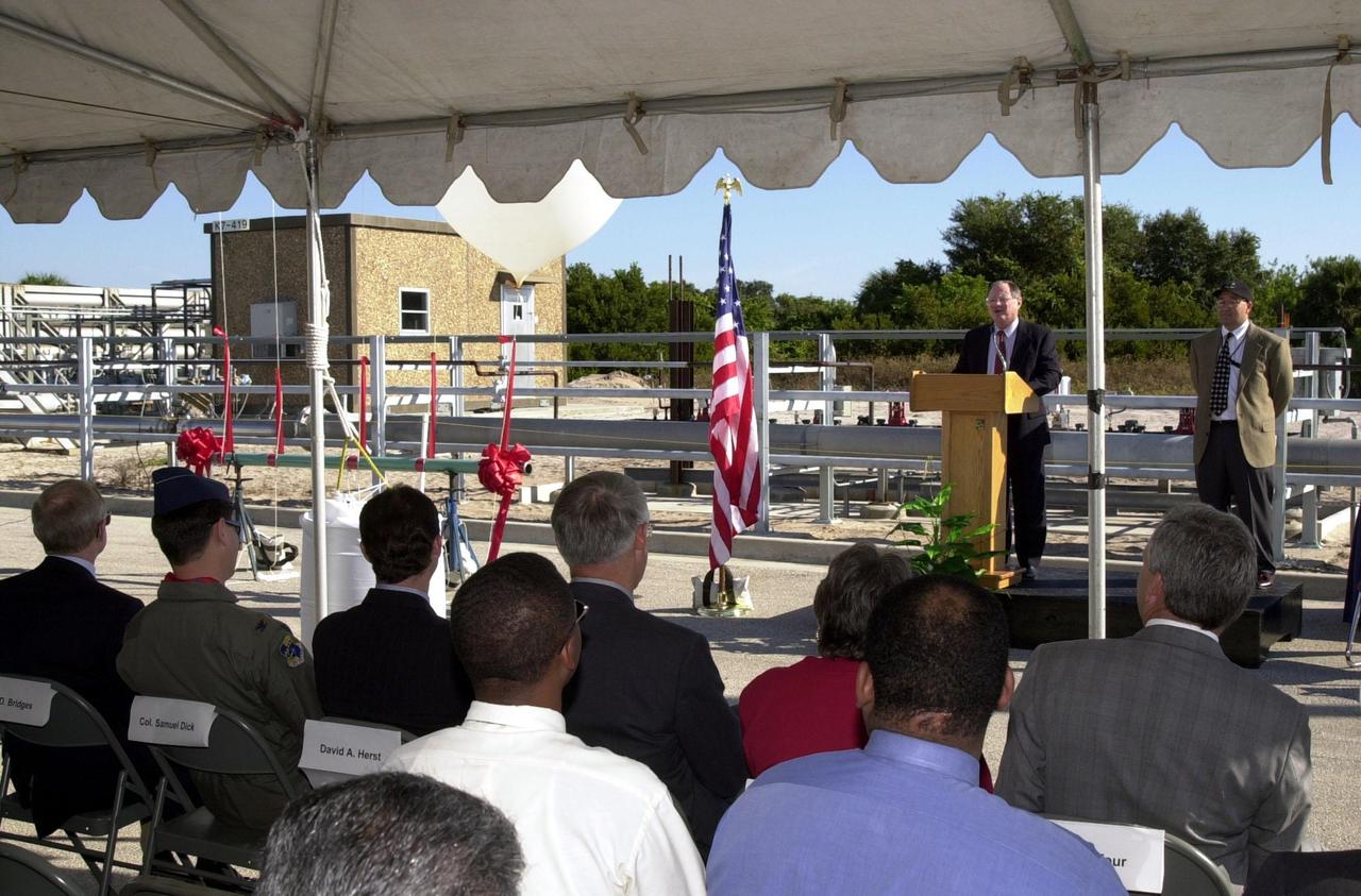 Jerry Jorgensen welcomes the audience to the commissioning of a new high-pressure helium pipeline at Kennedy Space Center. Jorgensen, with Space Gateway Support (SGS), is the pipeline project manager. To the right is Ramon Lugo, acting executive director, JPMO. Others at the ceremony were Center Director Roy Bridges; Col. Samuel Dick, representative of the 45th Space Wing; David Herst, director, Delta IV Launch Sites; Pierre Dufour, president and CEO, Air Liquide America Corporation; and Michael Butchko, president, SGS. The pipeline will service launch needs at the new Delta IV Complex 37 at Cape Canaveral Air Force Station. The nine-mile-long buried pipeline will also serve as a backup helium resource for Shuttle launches. Nearly one launch’s worth of helium will be available in the pipeline to support a Shuttle pad in an emergency. The line originates at the Helium Facility on KSC and terminates in a meter station at the perimeter of the Delta IV launch pad