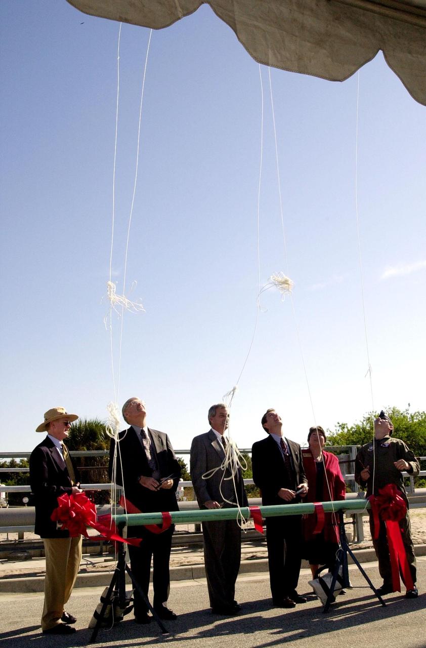 At the commissioning of a new high-pressure helium pipeline at Kennedy Space Center, participants cut the lines to helium-filled balloons. From left, they are Center Director Roy Bridges; Michael Butchko, president, SGS; Pierre Dufour, president and CEO, Air Liquide America Corporation; David Herst, director, Delta IV Launch Sites; Pamela Gillespie, executive administrator, office of Congressman Dave Weldon; and Col. Samuel Dick, representative of the 45th Space Wing. The nine-mile-long buried pipeline will service launch needs at the new Delta IV Complex 37 at Cape Canaveral Air Force Station. It will also serve as a backup helium resource for Shuttle launches. Nearly one launch’s worth of helium will be available in the pipeline to support a Shuttle pad in an emergency. The line originates at the Helium Facility on KSC and terminates in a meter station at the perimeter of the Delta IV launch pad. Others at the ceremony were Jerry Jorgensen, pipeline project manager, Space Gateway Support (SGS), and Ramon Lugo, acting executive director, JPMO