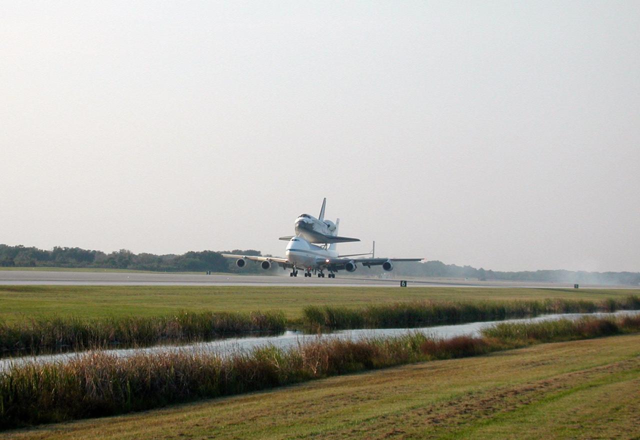 In the soft glow of a soon-to-set sun, the Shuttle Carrier Aircraft (SCA), with its unique orbiter passenger attached to its back, gently touches down on the runway at KSC’s Shuttle Landing Facility. The SCA is returning Discovery to KSC after the orbiter’s California landing at Edwards Air Force Base at the end of mission STS-92. Discovery will be demated from the SCA via the mate/demate device at the SLF and transported to the Orbiter Processing Facility bay 1. There it will undergo preparations for its next launch, STS-102, scheduled for February 2001