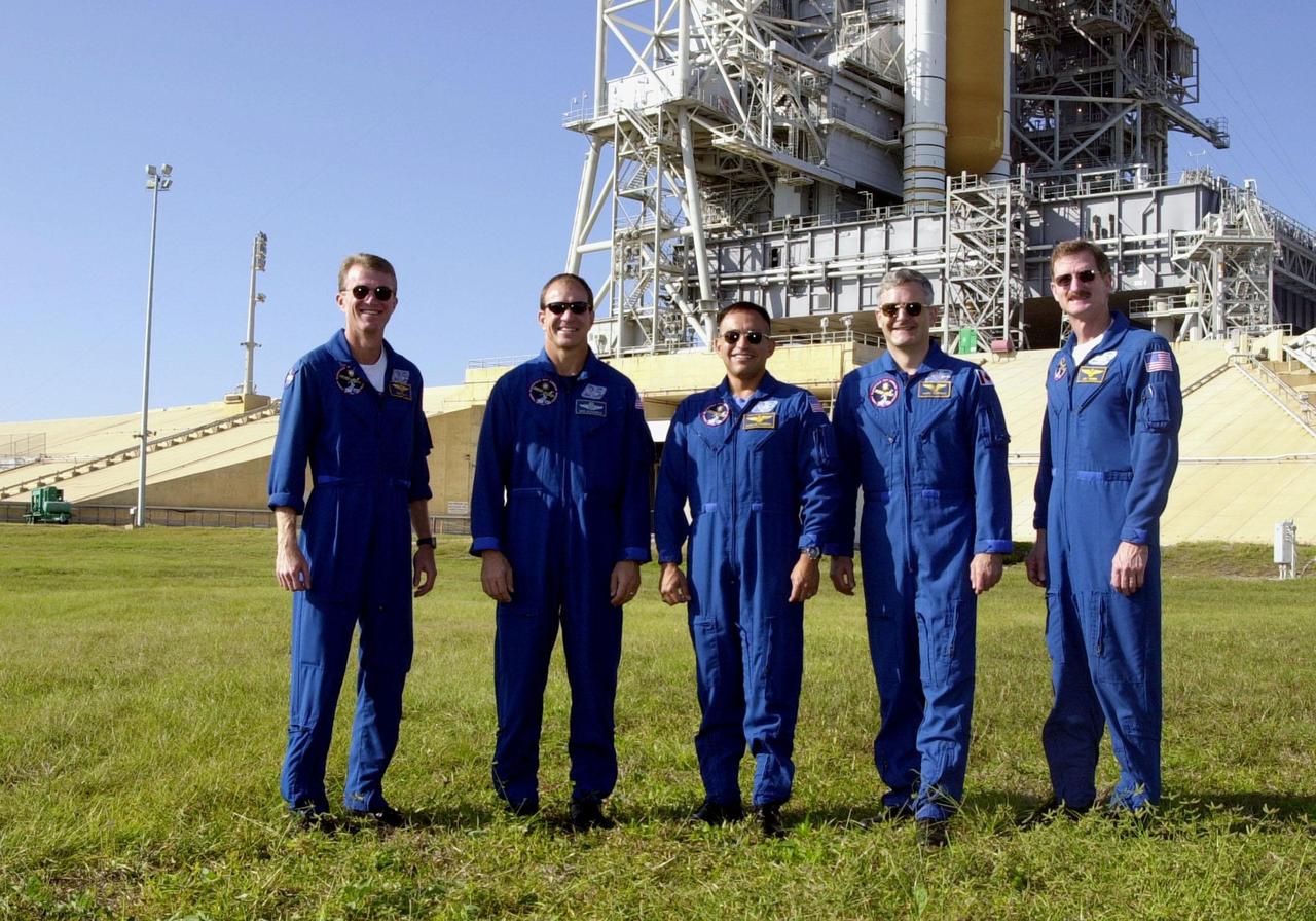 KENNEDY SPACE CENTER, Fla. -- The STS-97 crew pose for photographers at the base of Launch Pad 39B. They are, left to right, Commander Brent Jett, Pilot Mike Bloomfield and Mission Specialists Carlos Noriega, Marc Garneau and Joe Tanner. Garneau is with the Canadian Space Agency. The crew is at KSC to take part in Terminal Countdown Demonstration Test activities that include emergency egress training, familiarization with the payload, and a simulated launch countdown. Visible in the background are the solid rocket booster and external tank on Space Shuttle Endeavour. Mission STS-97is the sixth construction flight to the International Space Station. Its payload includes the P6 Integrated Truss Structure and a photovoltaic (PV) module, with giant solar arrays that will provide power to the Station. The mission includes two spacewalks to complete the solar array connections. STS-97 is scheduled to launch Nov. 30 at about 10:05 p.m. EST