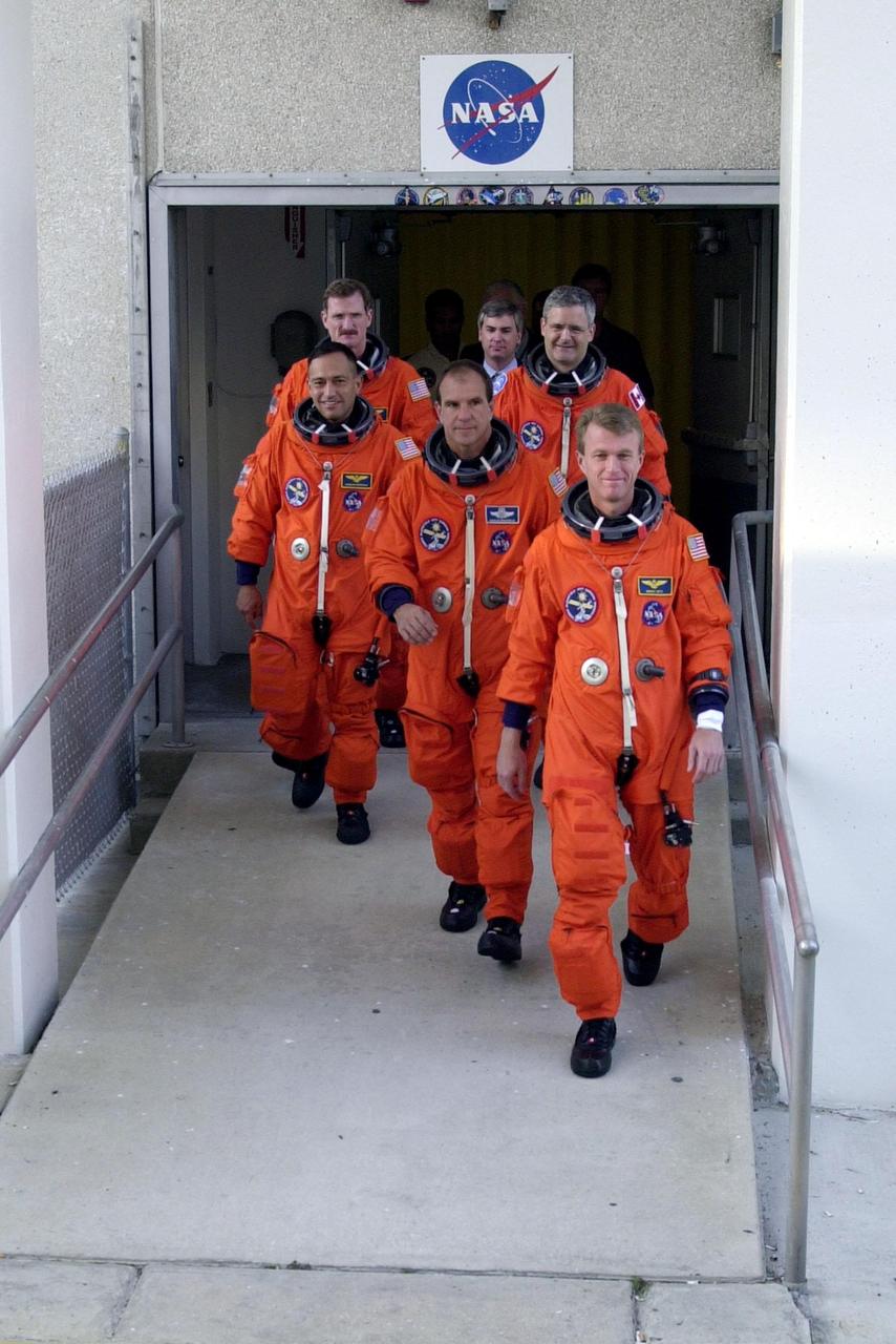 The STS-97 crew leaves the O&C Building on their way to Launch Pad 39B for a simulated launch countdown. Commander Brent Jett (right) leads the way with Pilot Mike Bloomfield behind him. Taking up the rear are (left) Mission Specialists Carlos Noriega, Joe Tanner and (right) Marc Garneau, who is with the Canadian Space Agency. The crew is taking part in Terminal Countdown Demonstration Test activities that include emergency egress training, familiarization with the payload, and the simulated launch countdown. Mission STS-97is the sixth construction flight to the International Space Station. Its payload includes the P6 Integrated Truss Structure and a photovoltaic (PV) module, with giant solar arrays that will provide power to the Station. The mission includes two spacewalks to complete the solar array connections. STS-97 is scheduled to launch Nov. 30 at about 10:05 p.m. EST