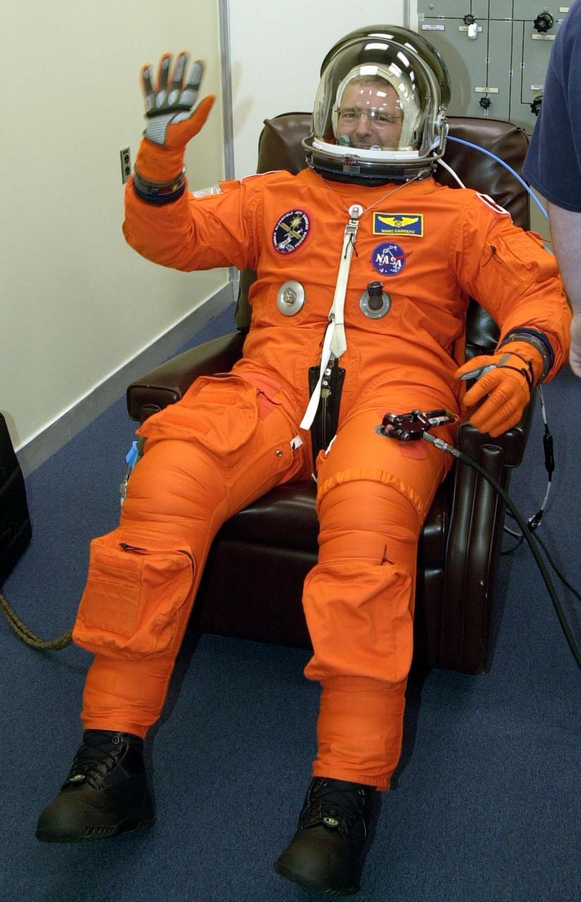 During pre-pack and fit check in the Operations and Checkout Building, STS-97 Mission Specialist Marc Garneau waves after getting his helmet on. Garneau is with the Canadian Space Agency. Mission STS-97 is the sixth construction flight to the International Space Station. Its payload includes the P6 Integrated Truss Structure and a photovoltaic (PV) module, with giant solar arrays that will provide power to the Station. The mission includes two spacewalks to complete the solar array connections. STS-97 is scheduled to launch Nov. 30 at about 10:06 p.m. EST