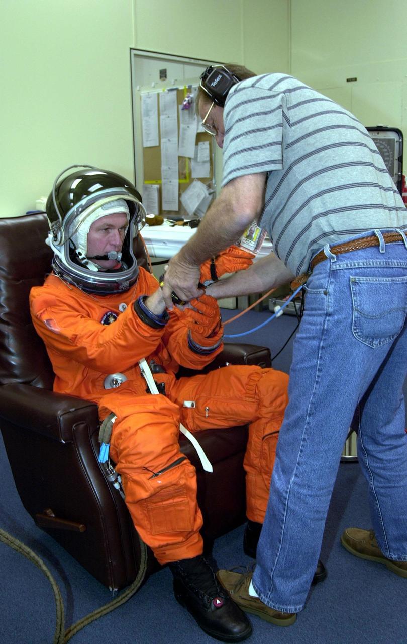 During pre-pack and fit check in the Operations and Checkout Building, STS-97 Commander Brent Jett gets help with his gloves from suit technician Bill Todd. Mission STS-97 is the sixth construction flight to the International Space Station. Its payload includes the P6 Integrated Truss Structure and a photovoltaic (PV) module, with giant solar arrays that will provide power to the Station. The mission includes two spacewalks to complete the solar array connections. STS-97 is scheduled to launch Nov. 30 at about 10:06 p.m. EST