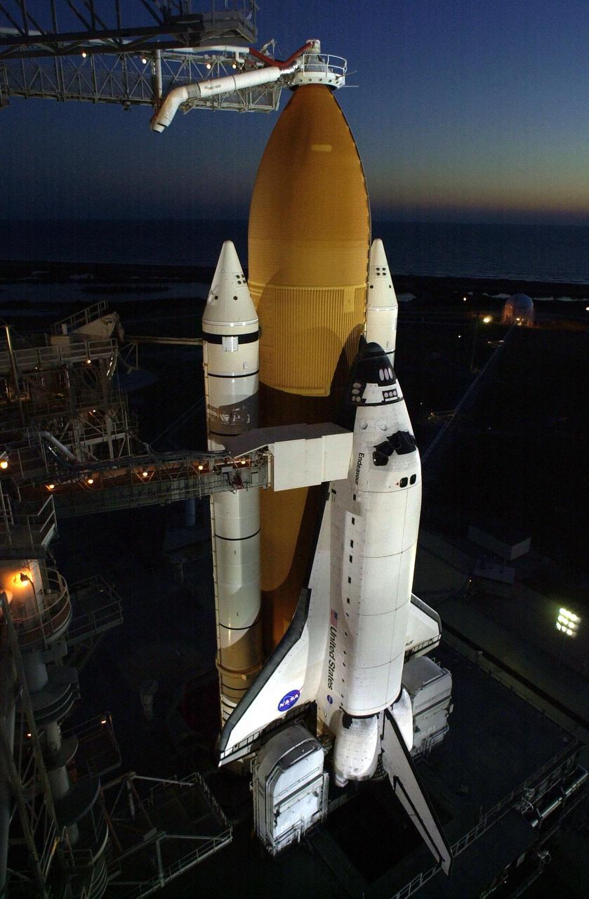 After rollback of the Rotating Service Structure, Space Shuttle Endeavour shines under spotlights. At the top of the external tank is the Gaseous Oxygen Vent Arm and its vent hood, known as the “beanie cap.” The hood is raised to clear the external tank 2.5 minutes before launch. Endeavour is targeted for launch Nov. 30 at about 10:06 p.m. EST on mission STS-97. In the background, the sky prepares for dawn. The mission to the International Space Station carries the P6 Integrated Truss Segment containing solar arrays and batteries that will be temporarily installed to the Unity connecting module by the Z1 truss, recently delivered to and installed on the Station on mission STS-92. The two solar arrays are each more than 100 feet long. They will capture energy from the sun and convert it to power for the Station. Two spacewalks will be required to install the solar array connections