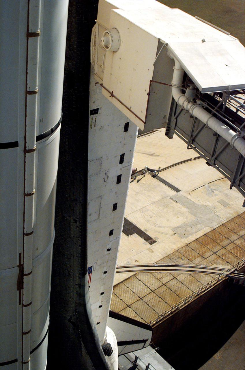 This view shows the pipe (center top) leading toward Endeavour from the side of the White Room at Launch Pad 39B. A loose bracket observed hanging down from the pipe delayed loading of Endeavour's external tank by several hours to allow technicians to remove it. A "U" bolt connects the bracket to a fire suppression water line attached to the exterior of the White Room. The loose bolt could have possibly created a debris hazard