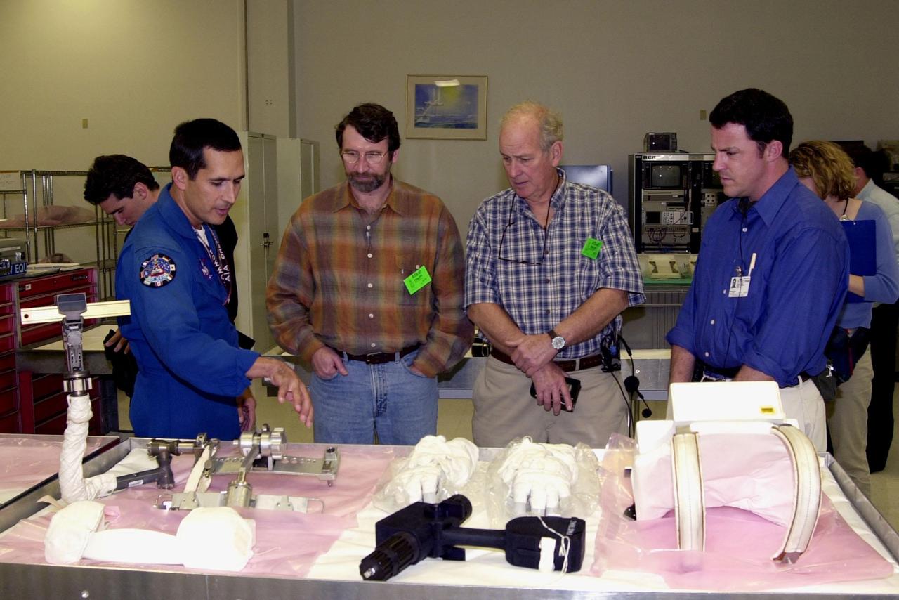 KENNEDY SPACE CENTER, FLA. -- Astronaut John Herrington (left) shows tools and equipment used in space to Norm Abram, master carpenter of television’s "This Old House" and "The New Yankee Workshop." At right are two of the film crew with Abram. Abram is at KSC to film an episode of "This Old House.