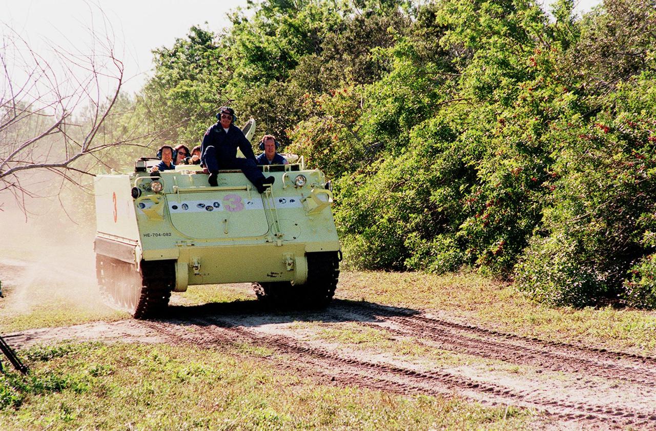 STS-99 Pilot Dominic Gorie, under the watchful eye of Capt. George Hoggard, a trainer with the KSC Fire Department, practices driving the M-113, an armored personnel carrier. Part of Terminal Countdown Demonstration Test (TCDT) activities, the M-113 could be used by the crew in the event of an emergency at the pad during which the crew must make a quick exit from the area. Riding in the rear are Mission Specialists Mamoru Mohri, who is with the National Space Development Agency (NASDA) of Japan, Janet Lynn Kavandi (Ph.D.) and Janice Voss (Ph.D.). TCDT provides the crew with simulated countdown exercises, emergency egress training, and opportunities to inspect the mission payloads in the orbiter's payload bay. STS-99 is the Shuttle Radar Topography Mission, which will chart a new course, using two antennae and a 200-foot-long section of space station-derived mast protruding from the payload bay to produce unrivaled 3-D images of the Earth's surface. The result of the Shuttle Radar Topography Mission could be close to 1 trillion measurements of the Earth's topography. Besides contributing to the production of better maps, these measurements could lead to improved water drainage modeling, more realistic flight simulators, better locations for cell phone towers, and enhanced navigation safety. Launch of Endeavour on the 11-day mission is scheduled for Jan. 31 at 12:47 p.m. EST