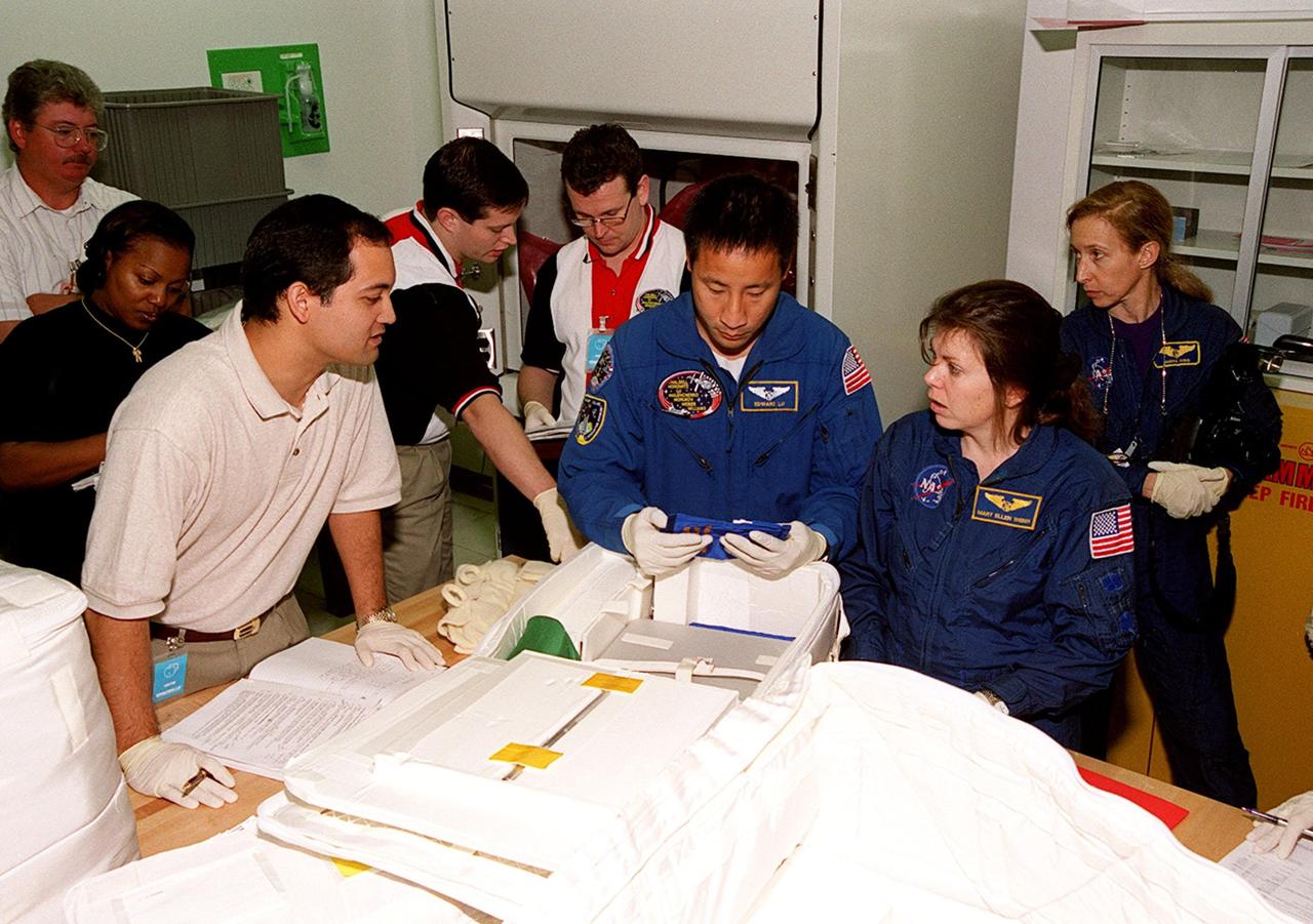 KENNEDY SPACE CENTER, FLA. -- With help from technicians at SPACEHAB, in Cape Canaveral, members of the STS-101 crew take part in a Crew Equipment Interface Test, which gives them an opportunity to look over equipment and payloads that will fly on the mission. In the center is Mission Specialist Edward Tsang Lu; at right is Mission Specialist Mary Ellen Weber (Ph.D.); in the background right is astronaut Marsha Ivins, who is assigned to mission STS-98 and is a veteran of four space flights. Her last flight, STS-81, including docking with the Russian Mir, and carrying the SPACEHAB double module to transfer tons of food and other cargo. On mission STS-101, Space Shuttle Atlantis will also be carrying the SPACEHAB Double Module, which will carry internal logistics and resupply cargo for station outfitting. Launch of Atlantis is scheduled no earlier than April 13, 2000
