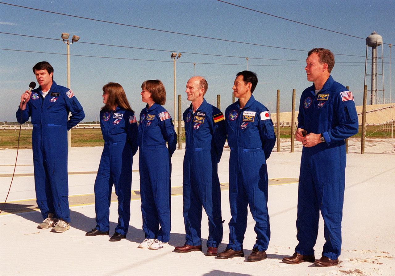 KENNEDY SPACE CENTER, Fla. --  The STS-99 crew take time out during Terminal Countdown Demonstration Test (TCDT) activities to talk to the media. From left to right are Commander Kevin Kregel, Mission Specialists Janet Lynn Kavandi (Ph.D.), Janice Voss (Ph.D.), Gerhard Thiele and Mamoru Mohri, and Pilot Dominic Gorie. Thiele is with the European Space Agency and Mohri is with the National Space Development Agency (NASDA) of Japan. The TCDT provides the crew with simulated countdown exercises, emergency egress training, and opportunities to inspect the mission payloads in the orbiter's payload bay. STS-99 is the Shuttle Radar Topography Mission, which will chart a new course, using two antennae and a 200-foot-long section of space station-derived mast protruding from the payload bay to produce unrivaled 3-D images of the Earth's surface. The result of the Shuttle Radar Topography Mission could be close to 1 trillion measurements of the Earth's topography. Besides contributing to the production of better maps, these measurements could lead to improved water drainage modeling, more realistic flight simulators, better locations for cell phone towers, and enhanced navigation safety. Launch of Endeavour on the 11-day mission is scheduled for Jan. 31 at 12:47 p.m. ES