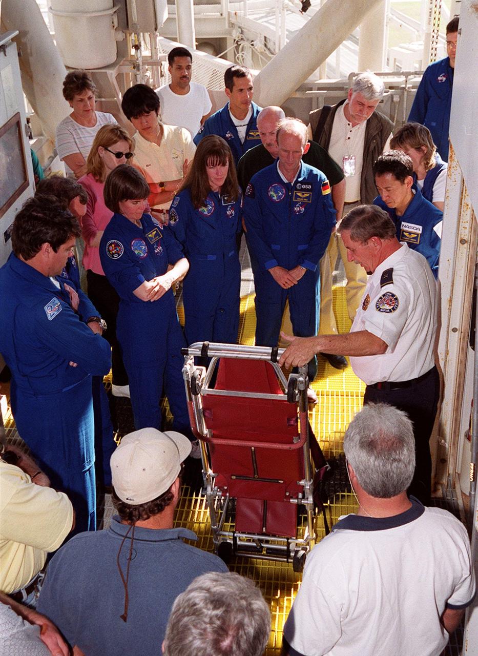 At Launch Pad 39A, members of the STS-99 crew and others look over part of the safety equipment. Standing left to right (in uniform) are Commander Kevin Kregel, Pilot Dominic Gorie, and Mission Specialists Janice Voss (Ph.D.), Janet Lynn Kavandi (Ph.D.), Gerhard Thiele and Mamoru Mohri. Thiele is with the European Space Agency and Mohri is with the National Space Development Agency (NASDA) of Japan. The crew are taking part in Terminal Countdown Demonstration Test activities, which provide them with simulated countdown exercises, emergency egress training, and opportunities to inspect the mission payloads in the orbiter's payload bay. STS-99 is the Shuttle Radar Topography Mission, which will chart a new course, using two antennae and a 200-foot-long section of space station-derived mast protruding from the payload bay to produce unrivaled 3-D images of the Earth's surface. The result of the Shuttle Radar Topography Mission could be close to 1 trillion measurements of the Earth's topography. Besides contributing to the production of better maps, these measurements could lead to improved water drainage modeling, more realistic flight simulators, better locations for cell phone towers, and enhanced navigation safety. Launch of Endeavour on the 11-day mission is scheduled for Jan. 31 at 12:47 p.m. EST