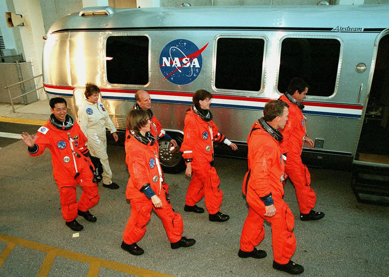 In their orange flight suits, the STS-99 crew head toward the &quot;astrovan&quot; that will take them to Launch Pad 39A for a simulated countdown exercise. From left to right are Mission Specialists Mamoru Mohri (waving), Gerhard Thiele, Janice Voss (Ph.D.) and Janet Lynn Kavandi (Ph.D.), Pilot Dominic Gorie and Commander Kevin Kregel. Mohri is with the National Space Development Agency (NASDA) of Japan and Thiele is with the European Space Agency. The crew are taking part in Terminal Countdown Demonstration Test activities, which provide them with simulated countdown exercises, emergency egress training, and opportunities to inspect the mission payloads in the orbiter's payload bay. STS-99 is the Shuttle Radar Topography Mission, which will chart a new course, using two antennae and a 200-foot-long section of space station-derived mast protruding from the payload bay to produce unrivaled 3-D images of the Earth's surface. The result of the Shuttle Radar Topography Mission could be close to 1 trillion measurements of the Earth's topography. Besides contributing to the production of better maps, these measurements could lead to improved water drainage modeling, more realistic flight simulators, better locations for cell phone towers, and enhanced navigation safety. Launch of Endeavour on the 11-day mission is scheduled for Jan. 31 at 12:47 p.m. EST