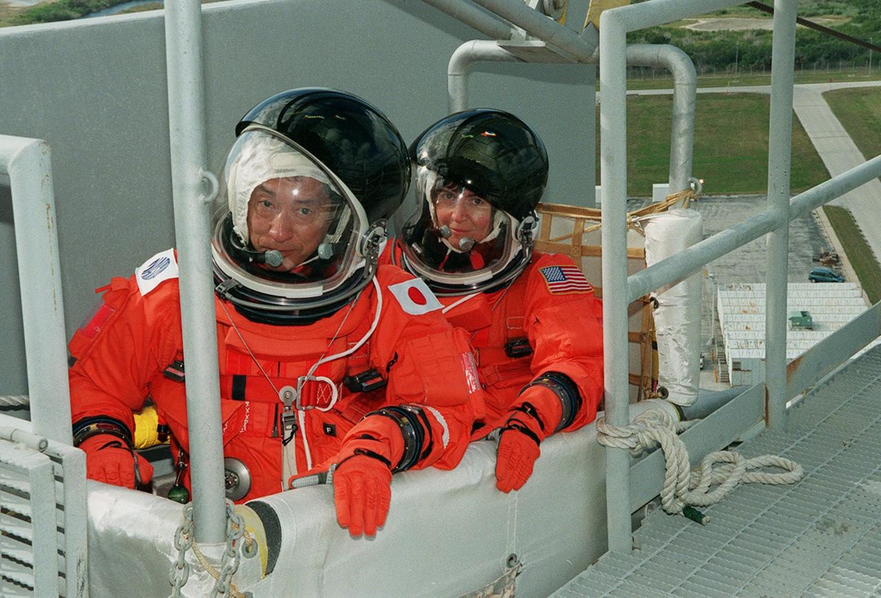 KENNEDY SPACE CENTER, Fla. --  At Launch Pad 39A, STS-99 Mission Specialists Mamoru Mohri (Ph.D.), who is with the National Space Development Agency (NASDA) of Japan, and Janice Voss (Ph.D.) practice emergency egress procedures in a slidewire basket. Seven slidewires, with flatbottom baskets suspended from each wire, extend from the Fixed Service Structure at the orbiter access arm level. These baskets could provide an escape route for the astronauts until the final 30 seconds of the countdown in case of an emergency. The crew is taking part in Terminal Countdown Demonstration Test (TCDT) activities that provide the crew with simulated countdown exercises, emergency egress training, and opportunities to inspect the mission payloads in the orbiter's payload bay. STS-99 is the Shuttle Radar Topography Mission, which will chart a new course, using two antennae and a 200-foot-long section of space station-derived mast protruding from the payload bay to produce unrivaled 3-D images of the Earth's surface. The result of the Shuttle Radar Topography Mission could be close to 1 trillion measurements of the Earth's topography. Besides contributing to the production of better maps, these measurements could lead to improved water drainage modeling, more realistic flight simulators, better locations for cell phone towers, and enhanced navigation safety. Launch of Endeavour on the 11-day mission is scheduled for Jan. 31 at 12:47 p.m. EST