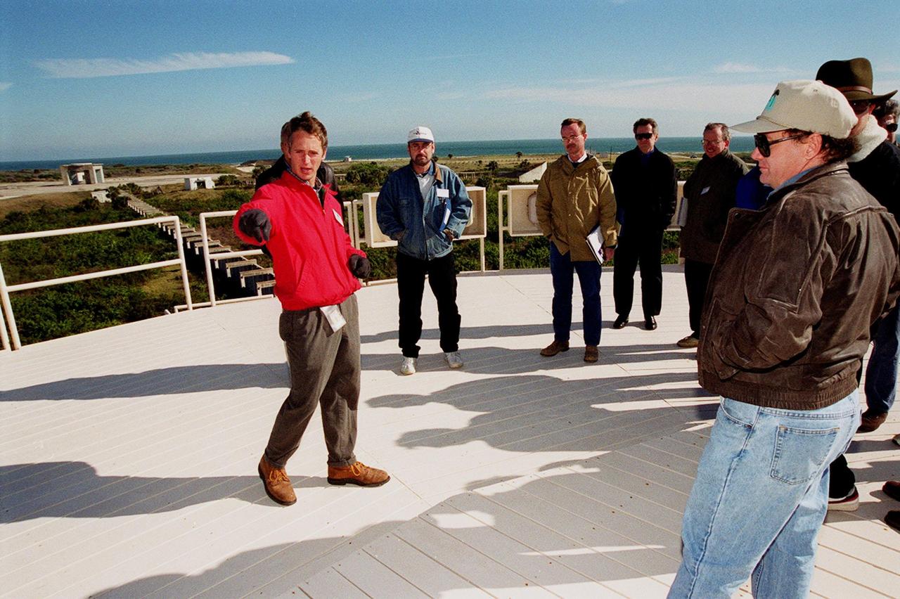 On top of the block house at Launch Complex 34, representatives from environmental and Federal agencies hear from Laymon Gray, with Florida State University, about the environmental research project that involves the Department of Defense, Environmental Protection Agency, Department of Energy and NASA in a groundwater cleanup effort. Concentrations of trichloroethylene solvent have been identified in the soil at the complex as a result of cleaning methods for rocket parts during the Apollo Program, which used the complex, in the 60s. The group formed the Interagency NDAPL Consortium (IDC) to study three contamination cleanup technologies: Six Phase Soil Heating, Steam Injection and In Situ Oxidation with Potassium Permanganate. All three methods may offer a way to remove the contaminants in months instead of decades. In the background (left) can be seen the cement platform and walkway from the block house to the pad. Beyond it is the Atlantic Ocean. KSC hosted a two-day conference that presented information and demonstrations of the three technologies being tested at the site