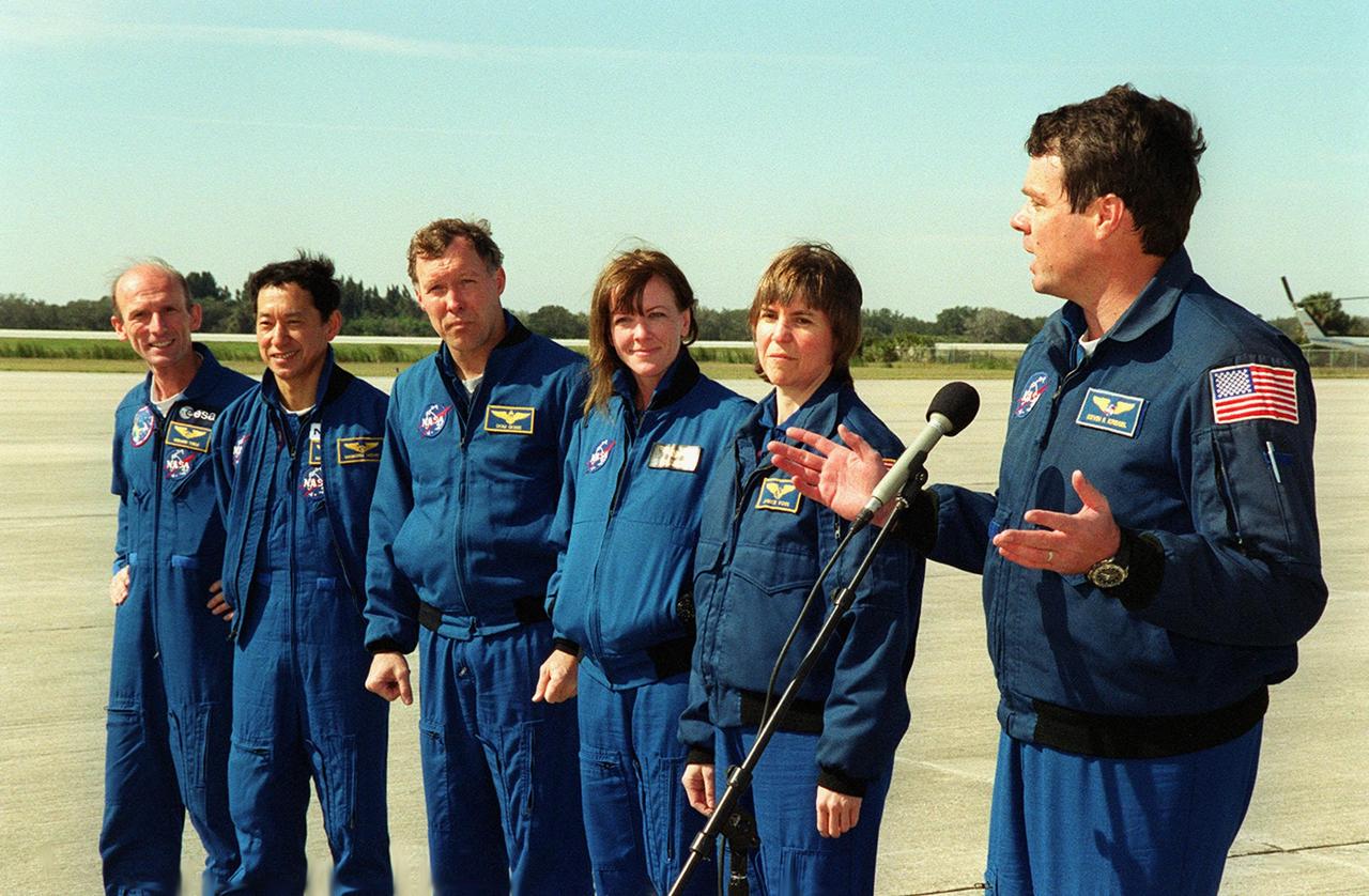 After arriving at KSC's Shuttle Landing Facility, the STS-99 crew pause to greet the media and Commander Kevin Kregel (right) introduces his crew: (from left) Mission Specialists Gerhard Thiele (Ph.D.) and Mamoru Mohri (Ph.D.); Pilot Dominic Gorie; and Mission Specialists Janet Lynn Kavandi (Ph.D.) and Janice Voss (Ph.D.). Thiele is with the European Space Agency and Mohri is with the National Space Development Agency (NASDA) of Japan. Over the next few days, the crew will review mission procedures, conduct test flights in the Shuttle Training Aircraft and undergo routine preflight medical exams. STS-99 is the Shuttle Radar Topography Mission, which will chart a new course, using two antennae and a 200-foot-long section of space station-derived mast protruding from the payload bay to produce unrivaled 3-D images of the Earth's surface. The result of the Shuttle Radar Topography Mission could be close to 1 trillion measurements of the Earth's topography. Besides contributing to the production of better maps, these measurements could lead to improved water drainage modeling, more realistic flight simulators, better locations for cell phone towers, and enhanced navigation safety. Launch of Endeavour is scheduled for Jan. 31 at 12:47 p.m. EST