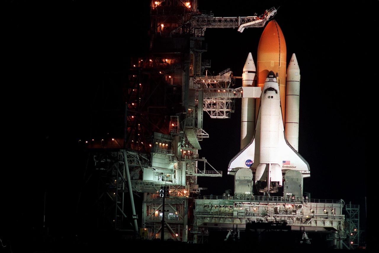 KENNEDY SPACE CENTER, Fla. --  Just after sundown, the Rotating Service Structure is rolled back to reveal Space Shuttle Endeavour, mated with its solid rocket boosters (left and right) and external tank (center), poised for launch on mission STS-99. Known as the Shuttle Radar Topography Mission (SRTM), STS-99 is scheduled to lift off 12:47 p.m. EST from Launch Pad 39A. The SRTM will chart a new course to produce unrivaled 3-D images of the Earth's surface, using two antennae and a 200-foot-long section of space station-derived mast protruding from the payload bay. The result of the Shuttle Radar Topography Mission could be close to 1 trillion measurements of the Earth's topography. Besides contributing to the production of better maps, these measurements could lead to improved water drainage modeling, more realistic flight simulators, better locations for cell phone towers, and enhanced navigation safety. The mission is expected to last about 11days, with Endeavour landing at KSC Friday, Feb. 11, at 4:55 p.m. EST
