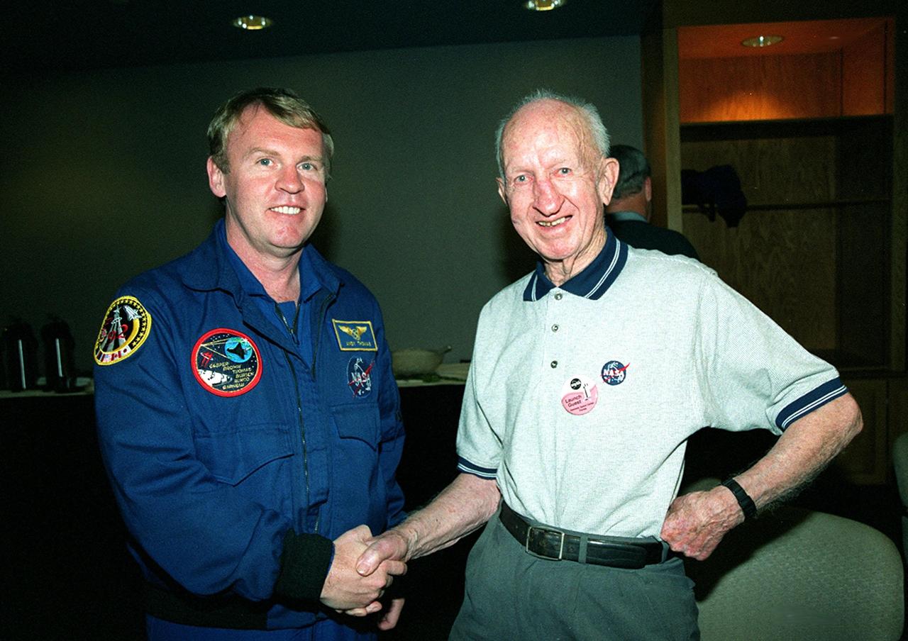 Astronaut Andy Thomas (left) greets 100-year-old Captain Ralph Charles, one of the VIPs attending the launch of STS-99. Charles also met NASA Administrator Dan Goldin. An aviator who has the distinction of being the oldest licensed pilot in the United States, Charles is still flying. He has experienced nearly a century of flight history, from the Wright Brothers to the Space Program. He took flying lessons from one of the first fliers trained by Orville Wright, first repaired then built airplanes, went barnstorming, operated a charter service in the Caribbean, and worked as a test pilot for the Curtiss Wright Airplane Co. Charles watches all the Shuttle launches from his home in Ohio and his greatest wish is to be able to watch one in person from KSC