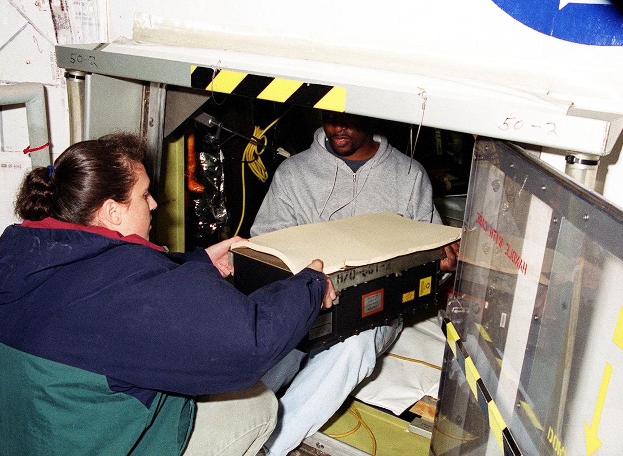 KENNEDY SPACE CENTER, FLA. -- At Launch Pad 39A, workers move the replacement Enhanced Main Events Controller (E-MEC) into Shuttle Endeavour's aft compartment in the payload bay. The original E-MEC became suspect during the Jan. 31 launch countdown and mission STS-99 was delayed when NASA managers decided to replace it. Each Shuttle carries two enhanced master events controllers (E-MECs), which provide relays for onboard flight computers to send signals to arm and fire pyrotechnics that separate the solid rockets and external tank during assent. Both E-MECs are needed for the Shuttle to be cleared for flight. Currently Endeavour and Columbia are the only two orbiters with the E-MECs. Built by Rockwell's Satellite Space Electronics Division, Anaheim, Calif., each unit weighs 65 pounds and is approximately 20 inches long, 13 inches wide and 8 inches tall. Previously, three Shuttle flights have been scrubbed or delayed due to faulty MECs: STS-73, STS-49 and STS-41-D. The next scheduled date for launch of STS-99 is Feb. 11 at 12:30 p.m. EST