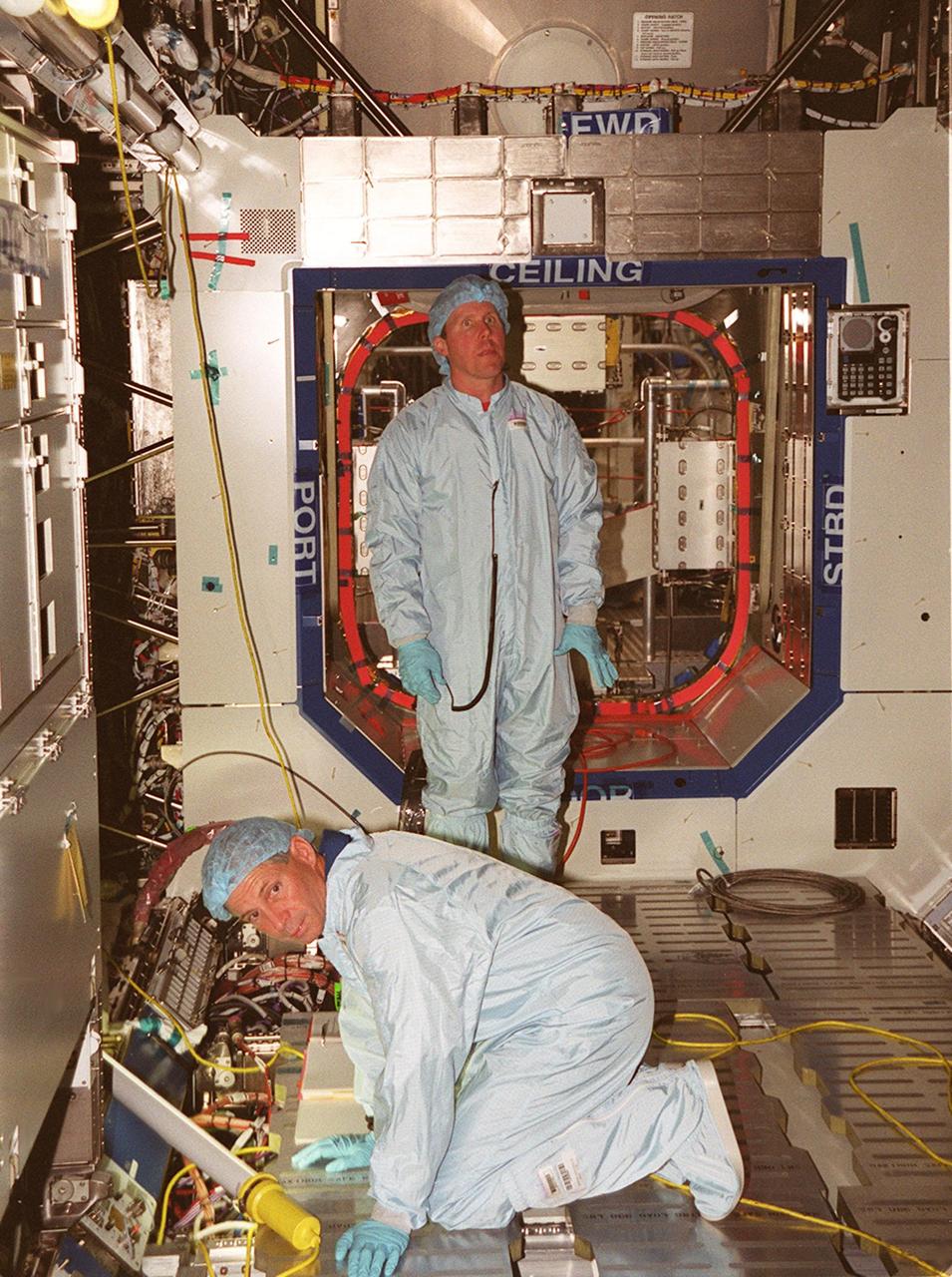 STS-98 Commander Kenneth D. Cockrell (left) and Mission Specialist Thomas D. Jones (Ph.D.) check out equipment in the U.S. Lab Destiny during a Multi-Equipment Interface Test. During the mission, Jones will help install the Lab on the International Space Station in a series of three space walks. The STS-98 mission will provide the station with science research facilities and expand its power, life support and control capabilities. The U.S. Laboratory Module continues a long tradition of microgravity materials research, first conducted by Skylab and later Shuttle and Spacelab missions. Destiny is expected to be a major feature in future research, providing facilities for biotechnology, fluid physics, combustion, and life sciences research. Others in the five-member crew on STS-98 are Pilot Mark L. Polansky, and Mission Specialists Robert L. Curbeam Jr. and Marsha S. Ivins. The Lab is planned for launch aboard Space Shuttle Atlantis on the sixth ISS flight, currently targeted no earlier than Aug. 19, 2000
