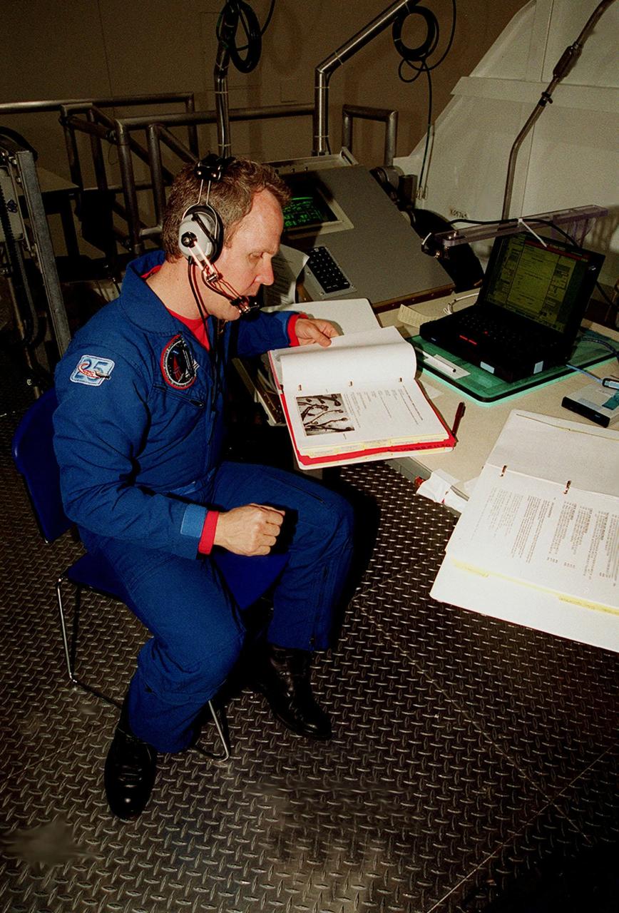 In the Space Station Processing Facility, STS-98 Mission Specialist Thomas D. Jones (Ph.D.) looks over documents as part of a Multi-Equipment Interface Test (MEIT) on the U.S. Lab Destiny. Other crew members taking part in the MEIT are Commander Kenneth D. Cockrell and Pilot Mark Polansky. The remaining members of the crew (not present for the MEIT) are and Mission Specialists Robert L. Curbeam Jr. and Marsha S. Ivins. During the STS-98 mission, the crew will install the Lab on the International Space Station during a series of three space walks. The mission will provide the station with science research facilities and expand its power, life support and control capabilities. The U.S. Laboratory Module continues a long tradition of microgravity materials research, first conducted by Skylab and later Shuttle and Spacelab missions. Destiny is expected to be a major feature in future research, providing facilities for biotechnology, fluid physics, combustion, and life sciences research. The Lab is planned for launch aboard Space Shuttle Atlantis on the sixth ISS flight, currently targeted no earlier than Aug. 19, 2000