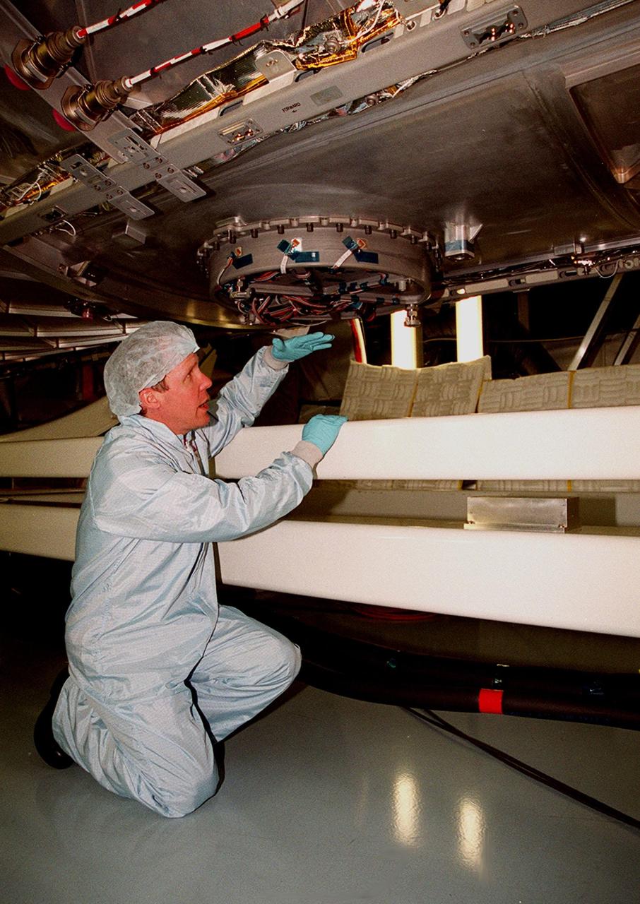 In the Space Station Processing Facility, STS-98 Mission Specialist Thomas D. Jones (Ph.D.) gets a closeup view of the cover on the window of the U.S. Lab Destiny. Along with Commander Kenneth D. Cockrell and Pilot Mark Polansky, Jones is taking part in a Multi-Equipment Interface Test (MEIT) on this significant element of the International Space Station. During the STS-98 mission, the crew will install the Lab on the station during a series of three space walks. The mission will provide the station with science research facilities and expand its power, life support and control capabilities. The U.S. Laboratory Module continues a long tradition of microgravity materials research, first conducted by Skylab and later Shuttle and Spacelab missions. Destiny is expected to be a major feature in future research, providing facilities for biotechnology, fluid physics, combustion, and life sciences research. The Lab is planned for launch aboard Space Shuttle Atlantis on the sixth ISS flight, currently targeted no earlier than Aug. 19, 2000