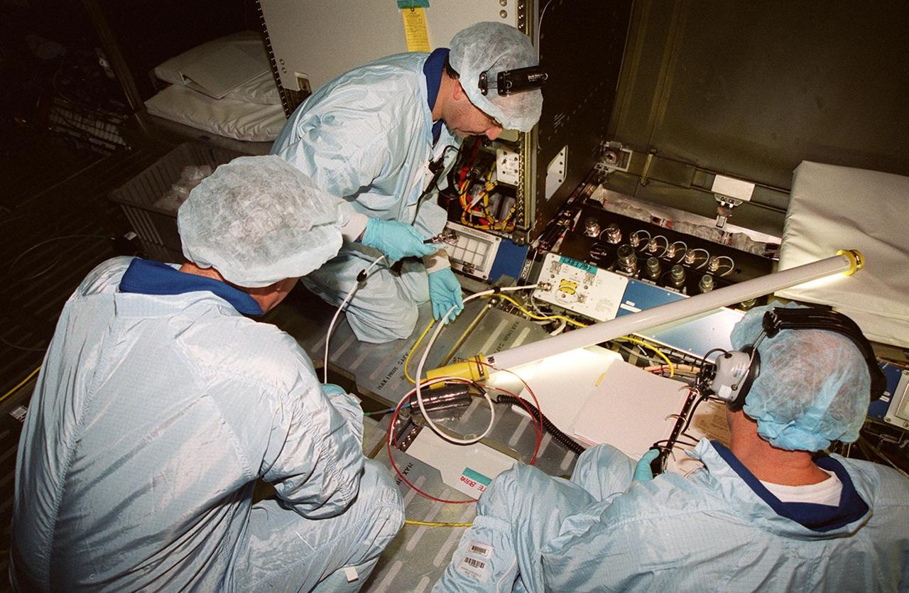 During a Multi-Equipment Interface Test (MEIT) in the U.S. Lab Destiny, which is in the Space Station Processing Facility, astronaut James Voss (left) joins STS-98 Pilot Mark Polansky (center) and Commander Kenneth D. Cockrell (right) in checking wiring against documentation on the floor. Also participating in the MEIT is Mission Specialist Thomas D. Jones (Ph.D.). Voss is assigned to mission STS-102 as part of the second crew to occupy the International Space Station. During the STS-98 mission, the crew will install the Lab on the station during a series of three space walks. The mission will provide the station with science research facilities and expand its power, life support and control capabilities. The U.S. Laboratory Module continues a long tradition of microgravity materials research, first conducted by Skylab and later Shuttle and Spacelab missions. Destiny is expected to be a major feature in future research, providing facilities for biotechnology, fluid physics, combustion, and life sciences research. The Lab is planned for launch aboard Space Shuttle Atlantis on the sixth ISS flight, currently targeted no earlier than Aug. 19, 2000