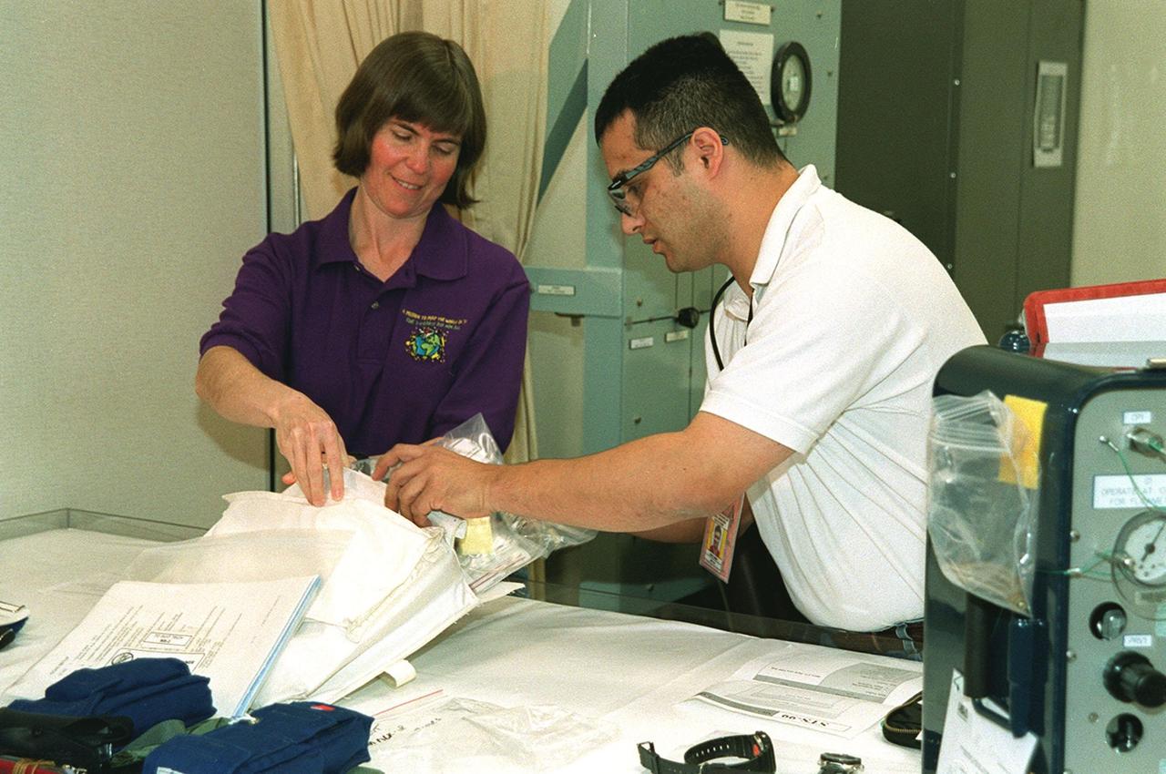 In the Operations and Checkout Building's suitup room, STS-99 Mission Specialist Janice Voss is helped with pre-pack and fit check by Santos Medina, with United Space Alliance. Voss and other crew members Commander Kevin Kregel, Pilot Dominic Gorie and Mission Specialists Janet Kavandi, Gerhard Thiele of Germany and Mamoru Mohri of Japan are preparing for launch of their mission on Feb. 11 at 12:30 p.m. EST aboard Space Shuttle Endeavour. STS-99 is the Shuttle Radar Topography Mission, which will produce unrivaled 3-D images of the Earth's surface. The result of the Shuttle Radar Topography Mission could be close to 1 trillion measurements of the Earth's topography. Landing is expected at KSC on Feb. 22 at 4:36 p.m. EST