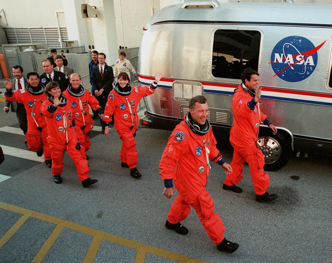 The STS-99 crew step eagerly to the &quot;Astrovan,&quot; the bus that will take them to Launch Pad 39A for liftoff of Space Shuttle Endeavour. In their orange launch and entry suits, they are (left to right) Mission Specialists Mamoru Mohri of Japan, Janice Voss, Gerhard Thiele of Germany and Janet Lynn Kavandi, Pilot Dominic Gorie and Commander Kevin Kregel. Mohri is with the National Space Development Agency (NASDA) of Japan, and Thiele is with the European Space Agency. Known as the Shuttle Radar Topography Mission (SRTM), STS-99 is scheduled for liftoff at 12:30 p.m. EST. The SRTM will chart a new course to produce unrivaled 3-D images of the Earth's surface. The result of the Shuttle Radar Topography Mission could be close to 1 trillion measurements of the Earth's topography. The mission is expected to last 11days, with Endeavour landing at KSC Tuesday, Feb. 22, at 4:36 p.m. EST. This is the 97th Shuttle flight and 14th for Shuttle Endeavour