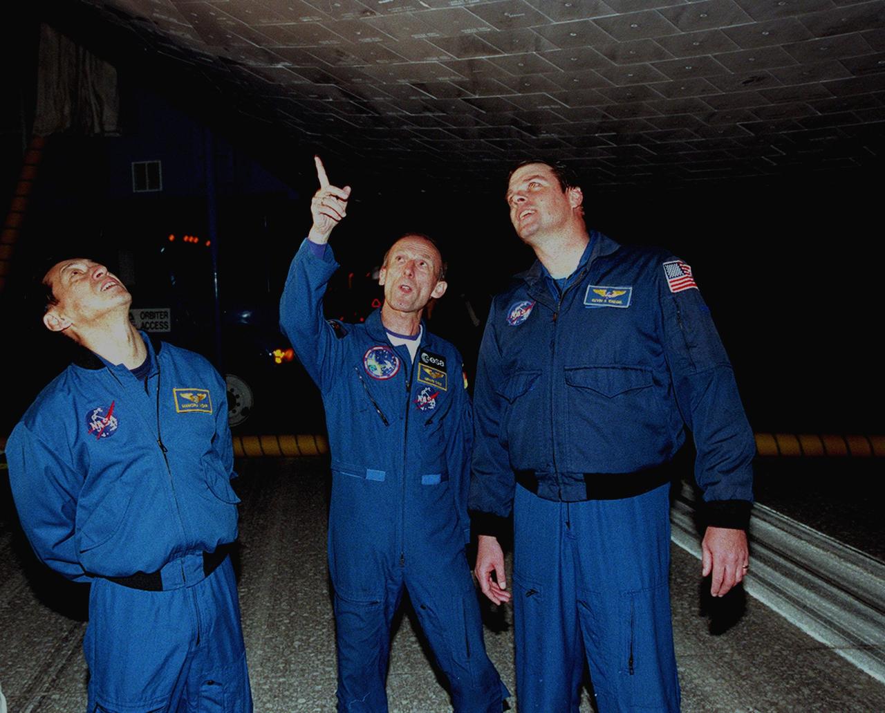 KENNEDY SPACE CENTER, FLA. -- On KSC's Shuttle Landing Facility, STS-99 crew members check the underside of Space Shuttle Endeavour after completing the 11-day, 5-hour, 38-minute-long mission. From left are Mission Specialists Mamoru Mohri of Japan and Gerhard Thiele of Germany, with Commander Kevin Kregel. Main gear touchdown was at 6:22:23 p.m. EST Feb. 22 , landing on orbit 181 of the mission. Nose gear touchdown was at 6:22:35 p.m.. EST, and wheel stop at 6:23:25 p.m. EST. The other crew members are Pilot Dominic Gorie and Mission Specialists Janet Kavandi and Janice Voss. The crew are returning from the Shuttle Radar Topography Mission, after mapping more than 47 million square miles of the Earth's surface. This was the 97th flight in the Space Shuttle program and the 14th for Endeavour, also marking the 50th landing at KSC, the 21st consecutive landing at KSC, and the 28th in the last 29 Shuttle flights