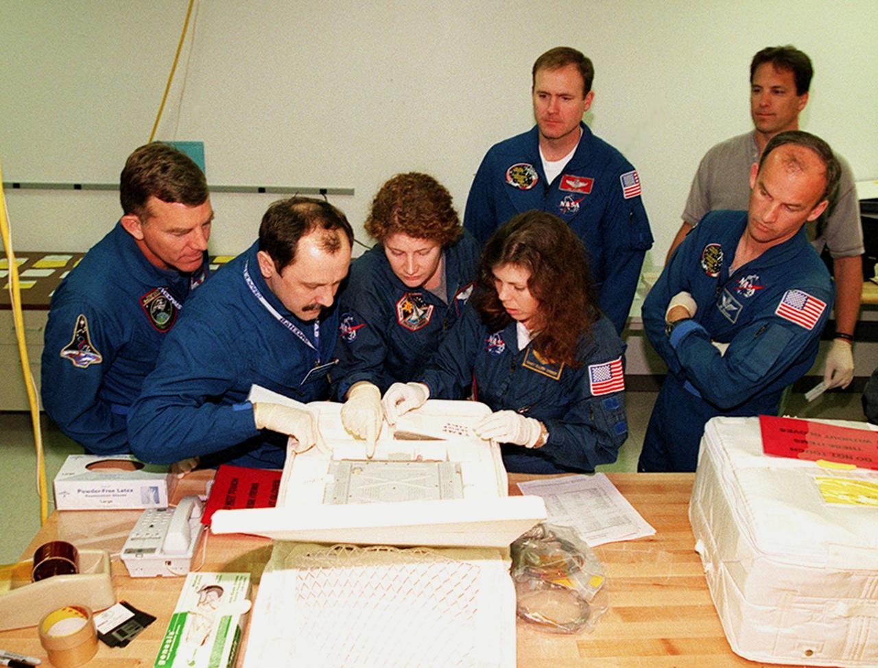 KENNEDY SPACE CENTER, FLA. -- At SPACEHAB, in Cape Canaveral, Fla., members of the STS-101 crew take part in Crew Equipment Interface Test (CEIT) activities, learning about some of the equipment they will be working with on their mission to the International Space Station. Looking over one of the elements are Mission Specialists James Voss, Yuri Usachev of Russia, Susan Helms and Mary Ellen Weber. Behind them is Commander James Halsell; at right is Mission Specialist Jeffrey Williams. The crew will be responsible for preparing the Space Station for the arrival of the Zvezda Service Module, expected to be launched by Russia in July 2000. Also, the crew will conduct one space walk to perform maintenance on the Space Station and deliver logistics and supplies. This will be the third assembly flight for the Space Station. STS-101 is scheduled to launch no earlier than April 13 from Launch Pad 39A