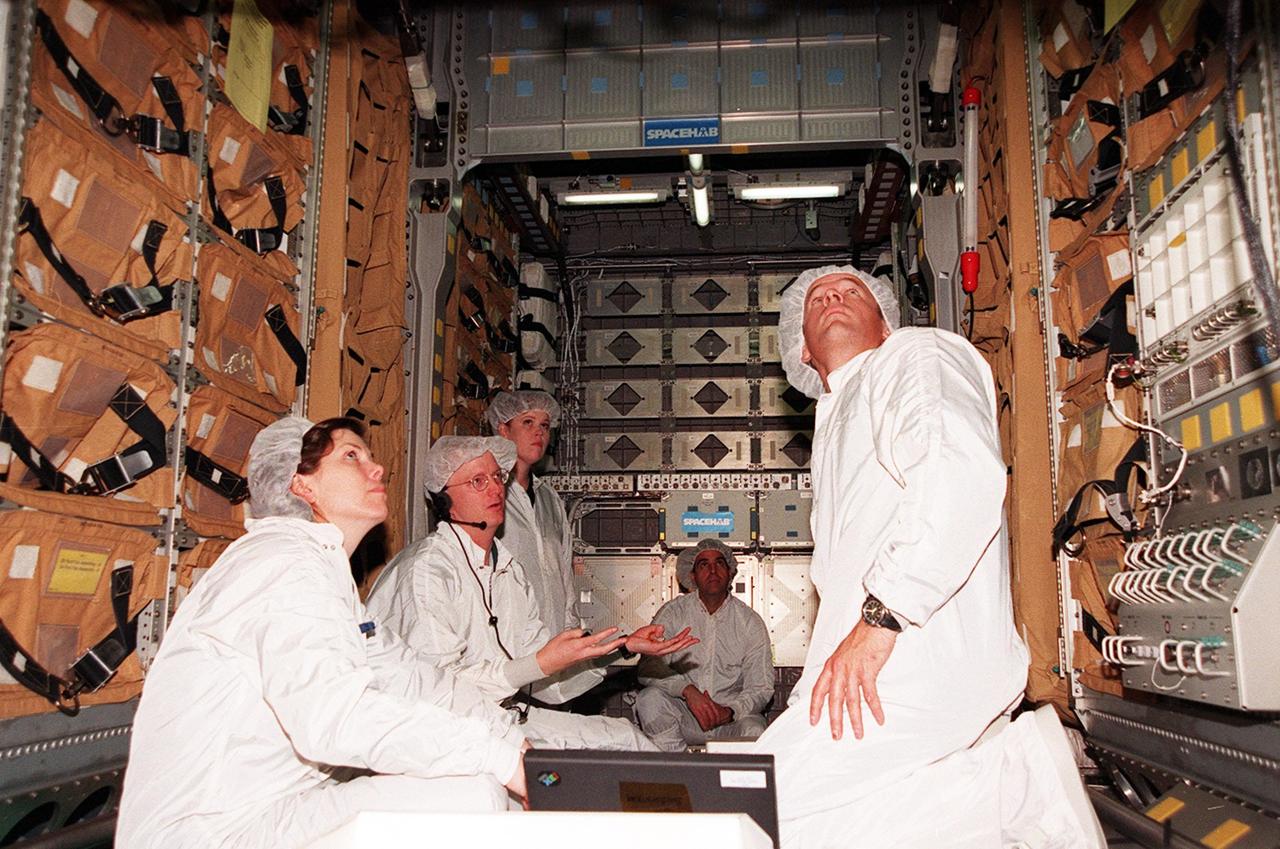 Members of the STS-101 crew look over equipment inside the SPACEHAB double module, part of the cargo on their mission. At left is Mission Specialist Mary Ellen Weber and at right is Mission Specialist Jeffrey Williams. They are taking part in Crew Equipment Interface Test (CEIT) activities to become familiar with equipment for their mission to the International Space Station. Other crew members not shown are Commander James Halsell, Pilot Scott Horowitz, and Mission Specialists James Voss, Susan Helms and Yuri Usachev. The STS-101 crew will be responsible for preparing the Space Station for the arrival of the Zvezda Service Module, expected to be launched by Russia in July 2000. Also, the crew will conduct one space walk to perform maintenance on the Space Station and deliver logistics and supplies. This will be the third assembly flight for the Space Station. STS-101 is scheduled to launch no earlier than April 13 from Launch Pad 39A